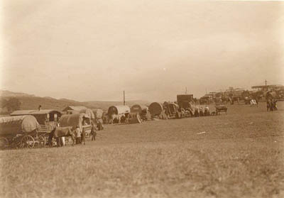 Brough Hill Fair; canvas roofed caravans and fairground ride